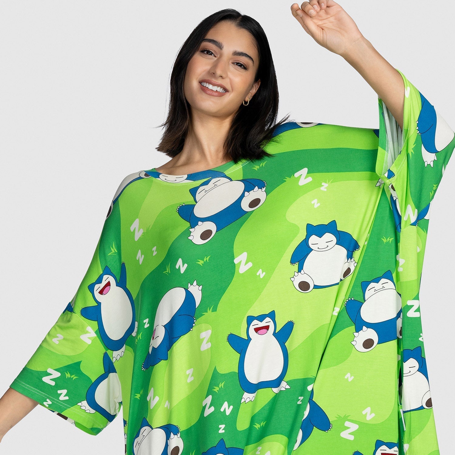 Woman wearing a green loose garment patterned with multiple sleeping Snorlax Pokémon and white 'Z' symbols