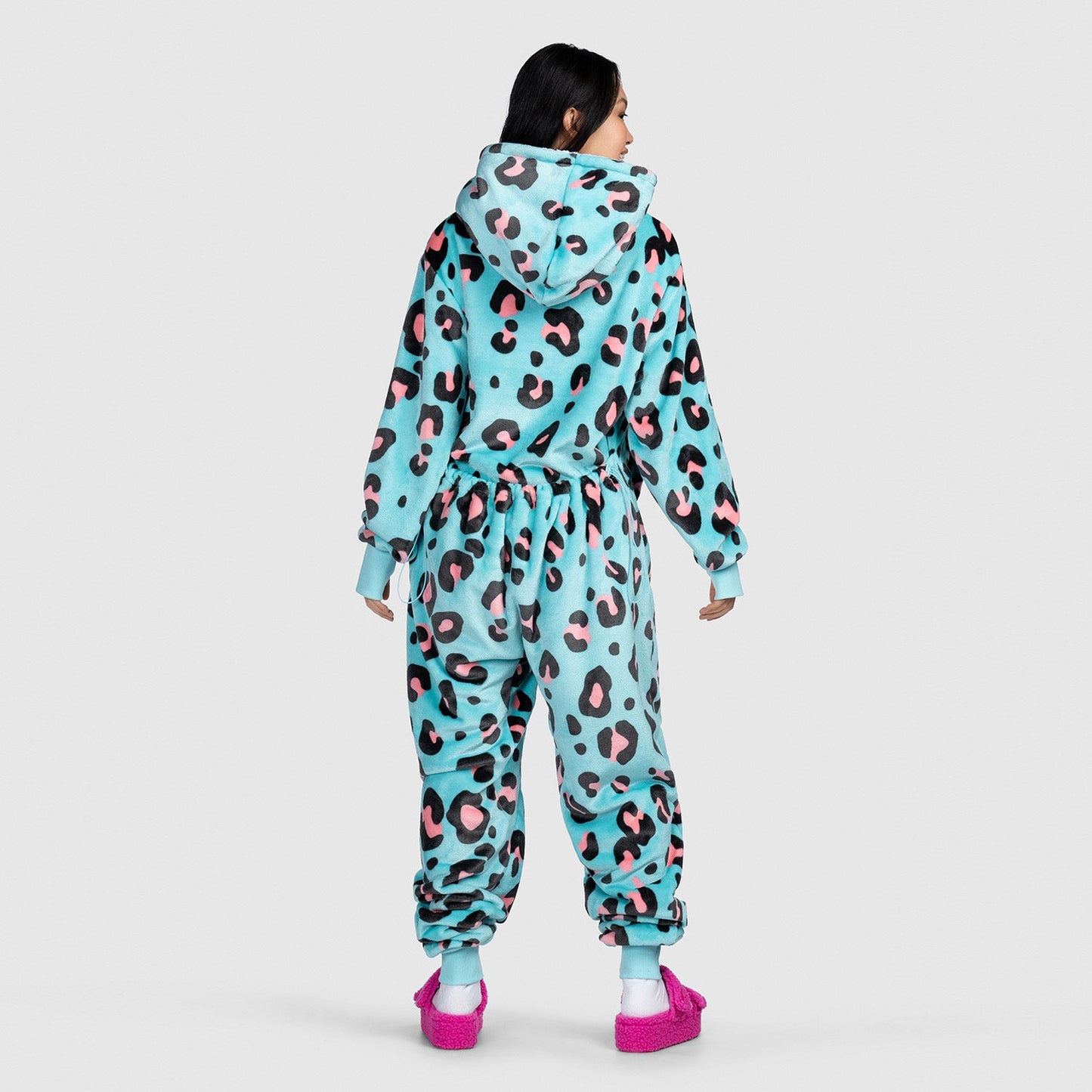 Person wearing a blue leopard-print hooded onesie with pink slippers, viewed from the back