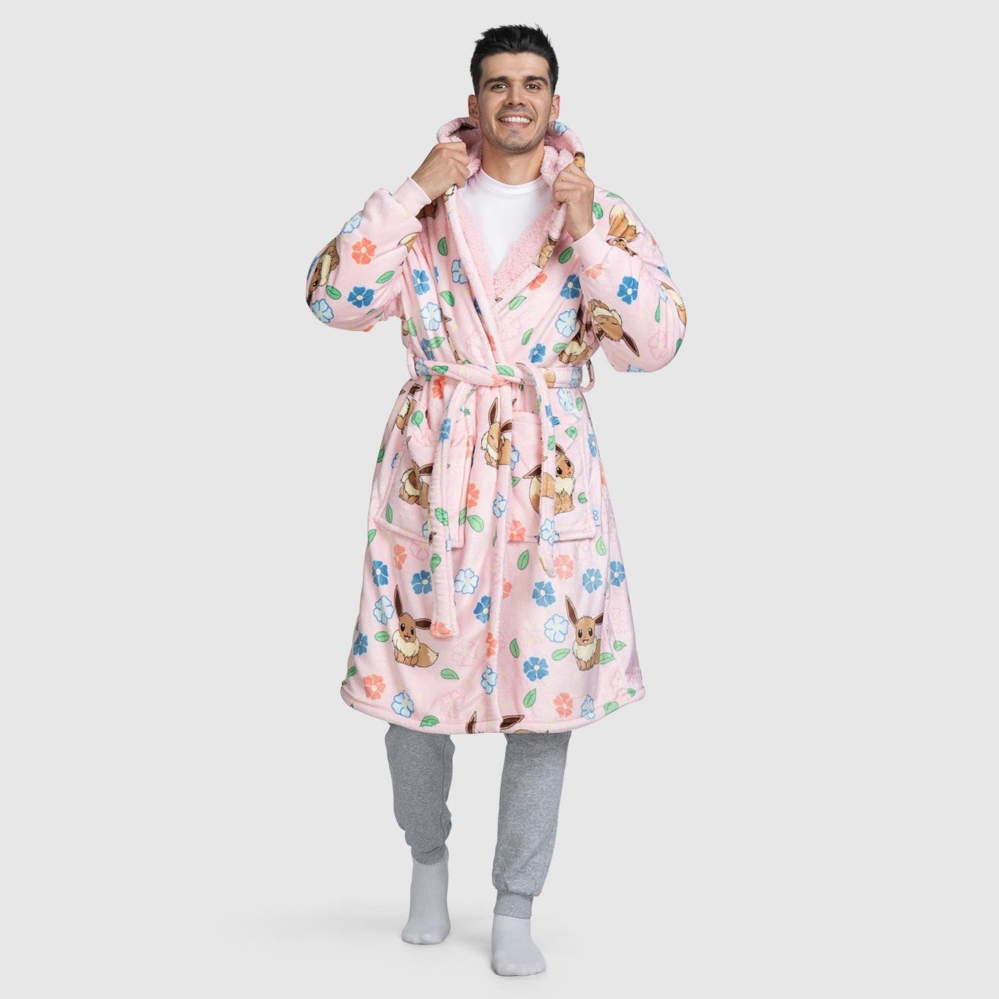 Man wearing a pink robe with Pokémon Eevee and flower patterns