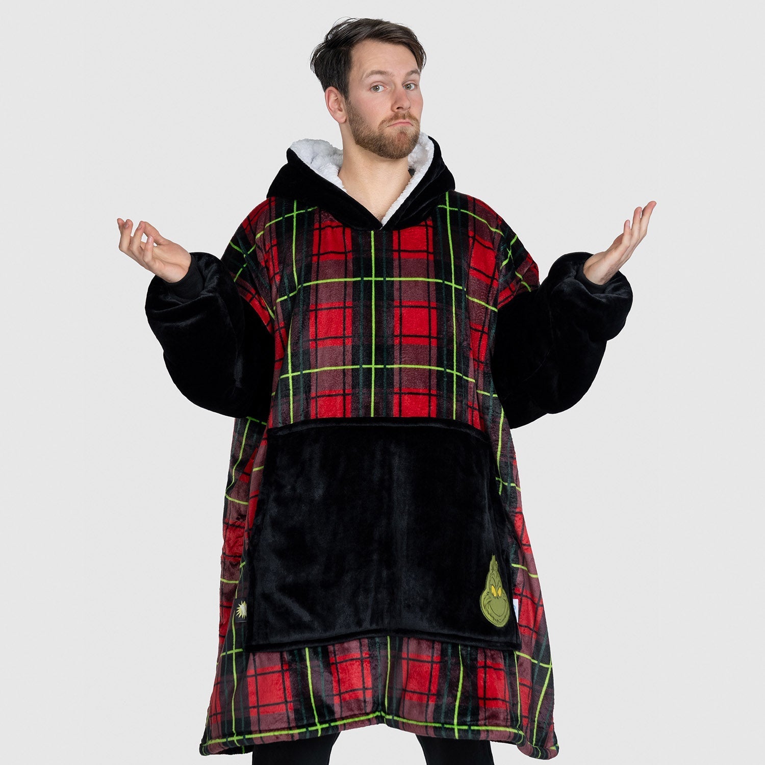 Man wearing a red and black plaid oversized hooded garment with black furry sleeves and front pocket, standing with arms outstretched. size: Jacob is 5'11" wearing a size OOD
