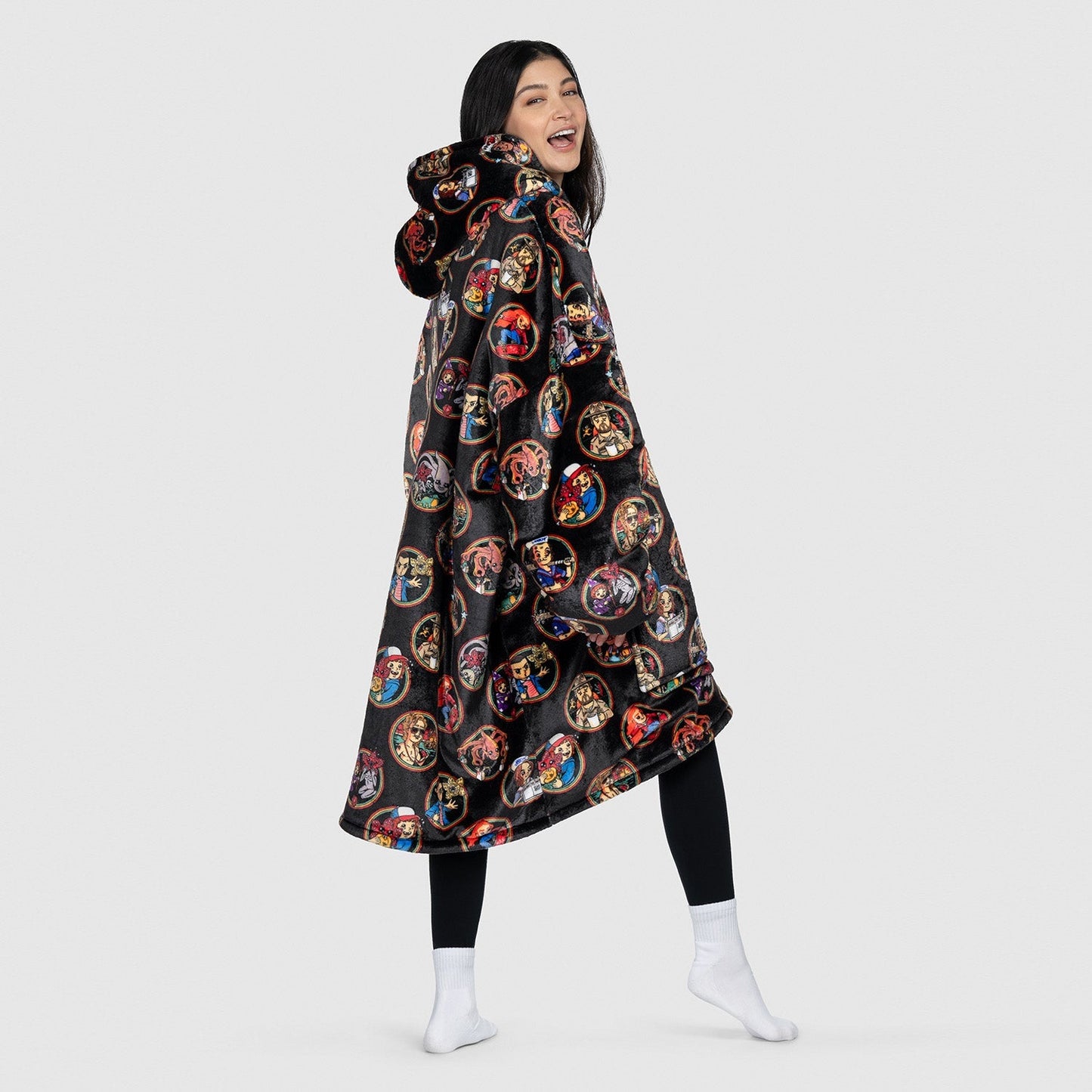 Woman wearing a black hooded garment with colorful circular patterns, standing and smiling, size reference: model is 5'2