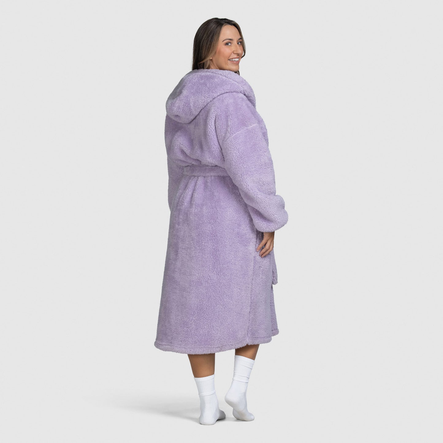 Woman wearing a lilac hooded robe, viewed from the back, smiling over her shoulder.