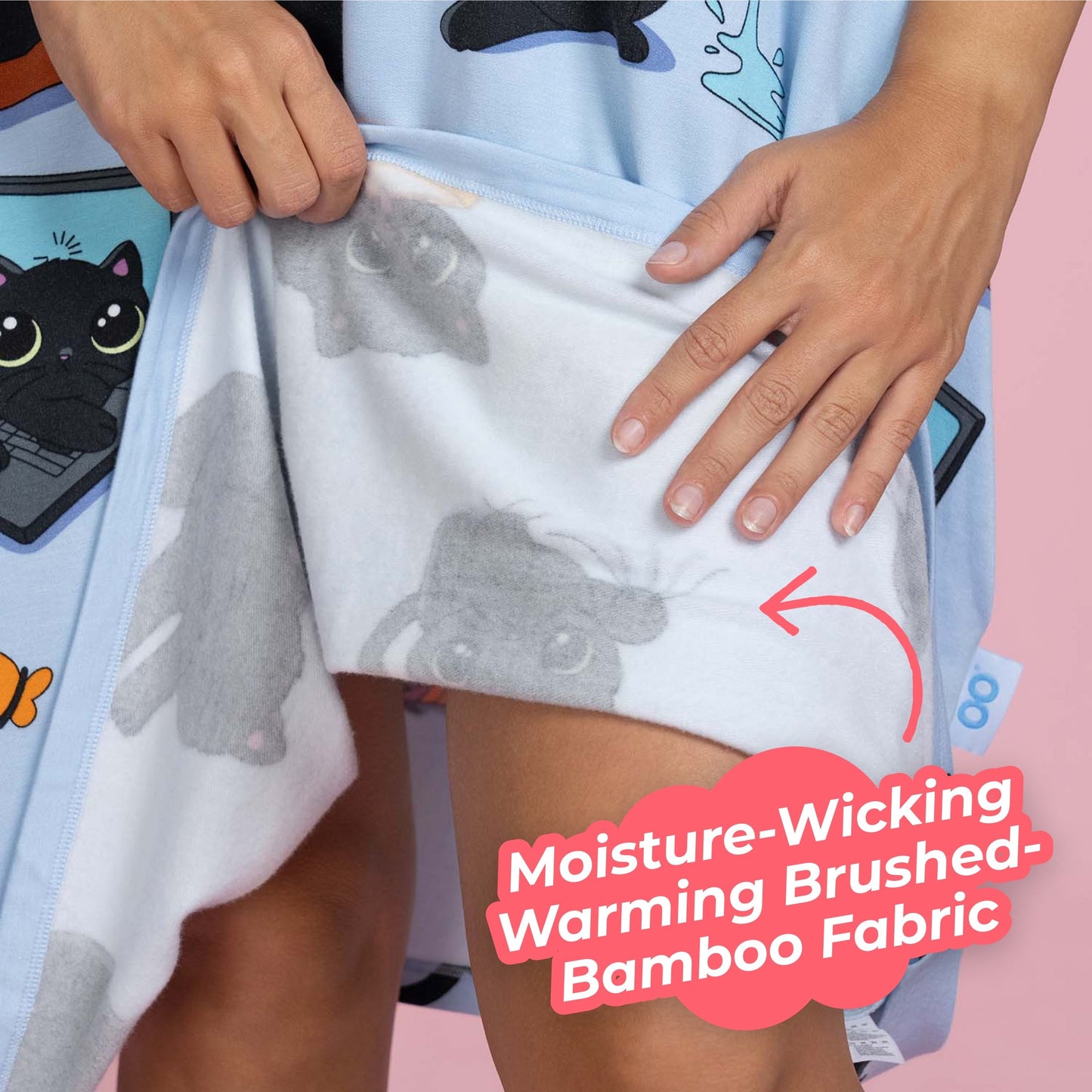 Person holding up a garment showing gray koala bear fabric pattern and a label reading 'Moisture-Wicking Warming Brushed-Bamboo Fabric'