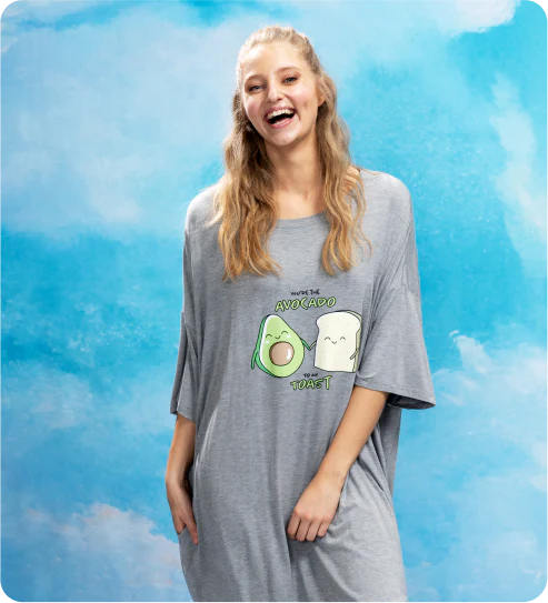 Smiling woman wearing gray oversized shirt with avocado and toast graphic saying