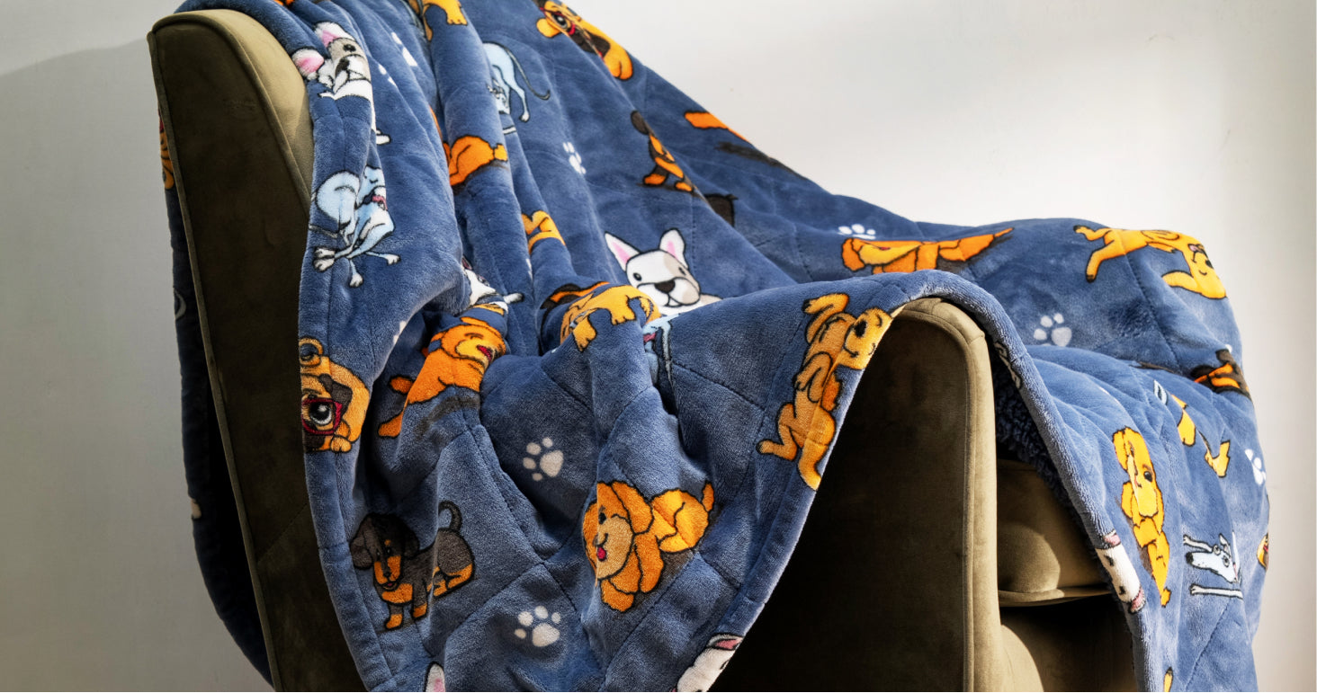 Blue blanket with cartoon dog patterns draped over a beige chair