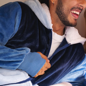 Man wearing a blue and white fleece jacket smiling, showing cozy apparel