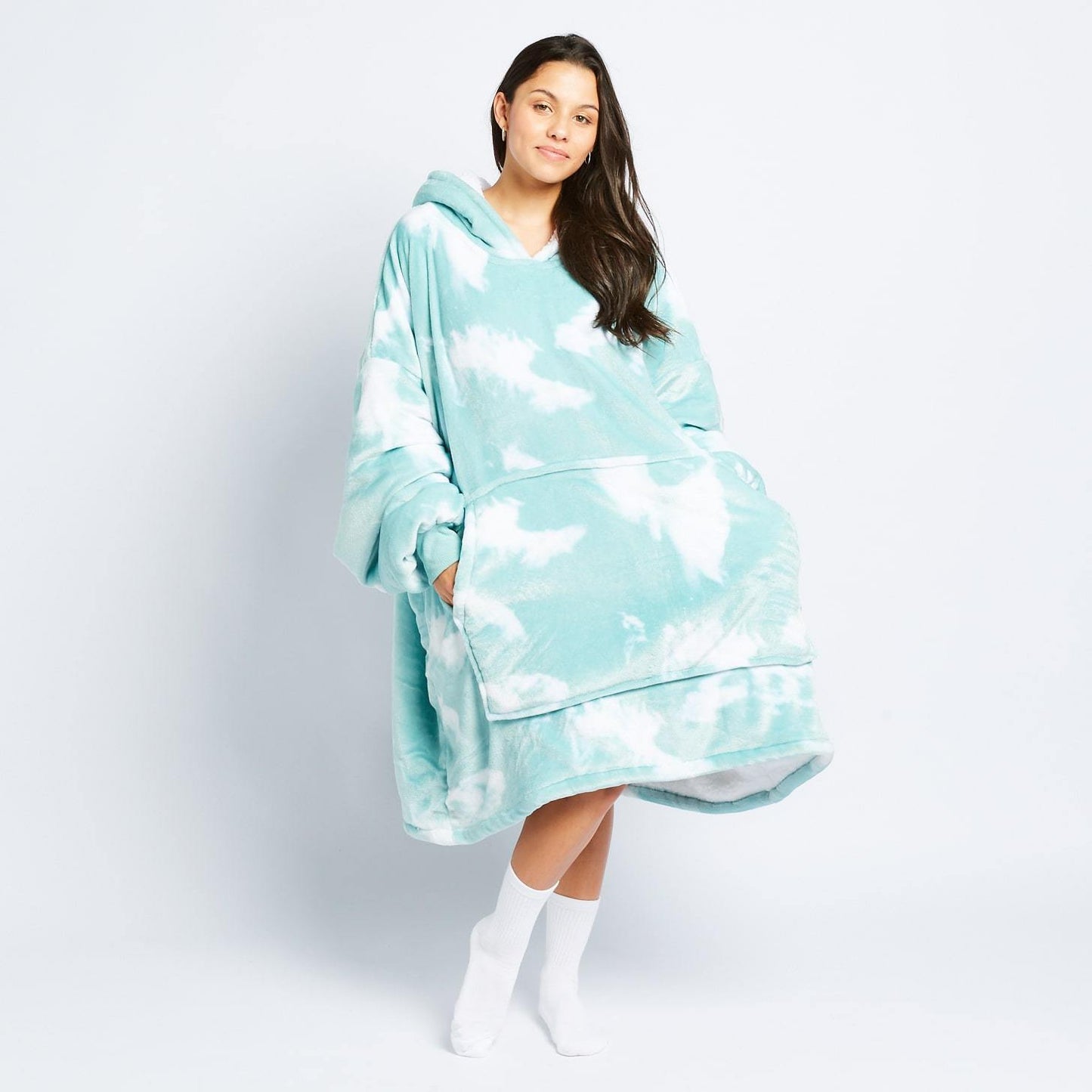 Woman wearing a light blue and white tie-dye oversized hooded wearable blanket with front pocket