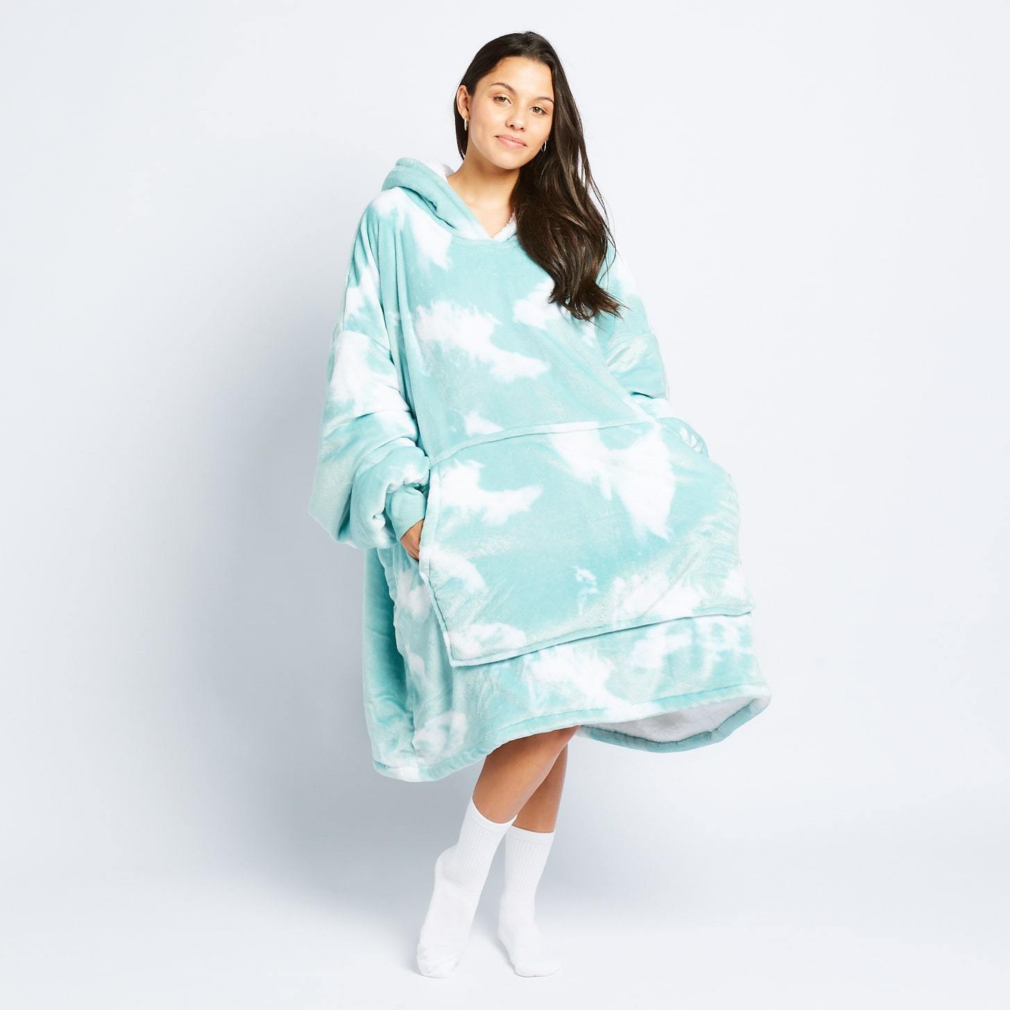 Woman wearing a light blue and white tie-dye oversized hooded wearable blanket with front pocket