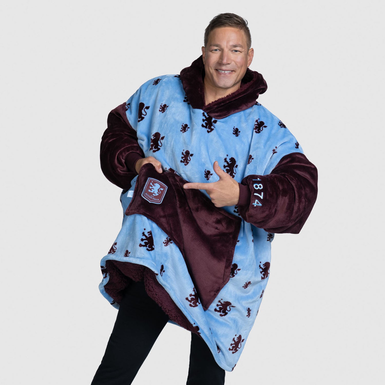 Man wearing a blue and maroon oversized hoodie blanket with lion patterns. size: Steven is 6” wearing a size OOD