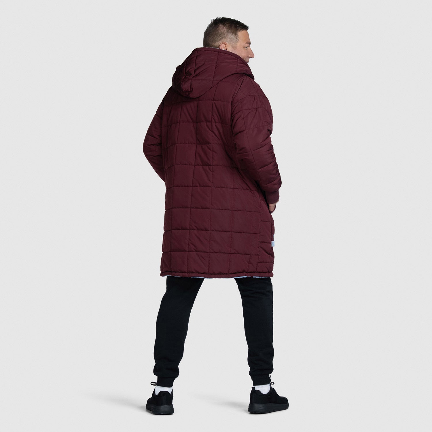Man wearing a long maroon quilted coat with hood, standing facing away. size: Steven is 6” wearing a size OOD