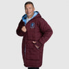Man wearing a maroon quilted hooded coat with a blue logo patch, standing with one hand in pocket. size: Steven is 6” wearing a size OOD