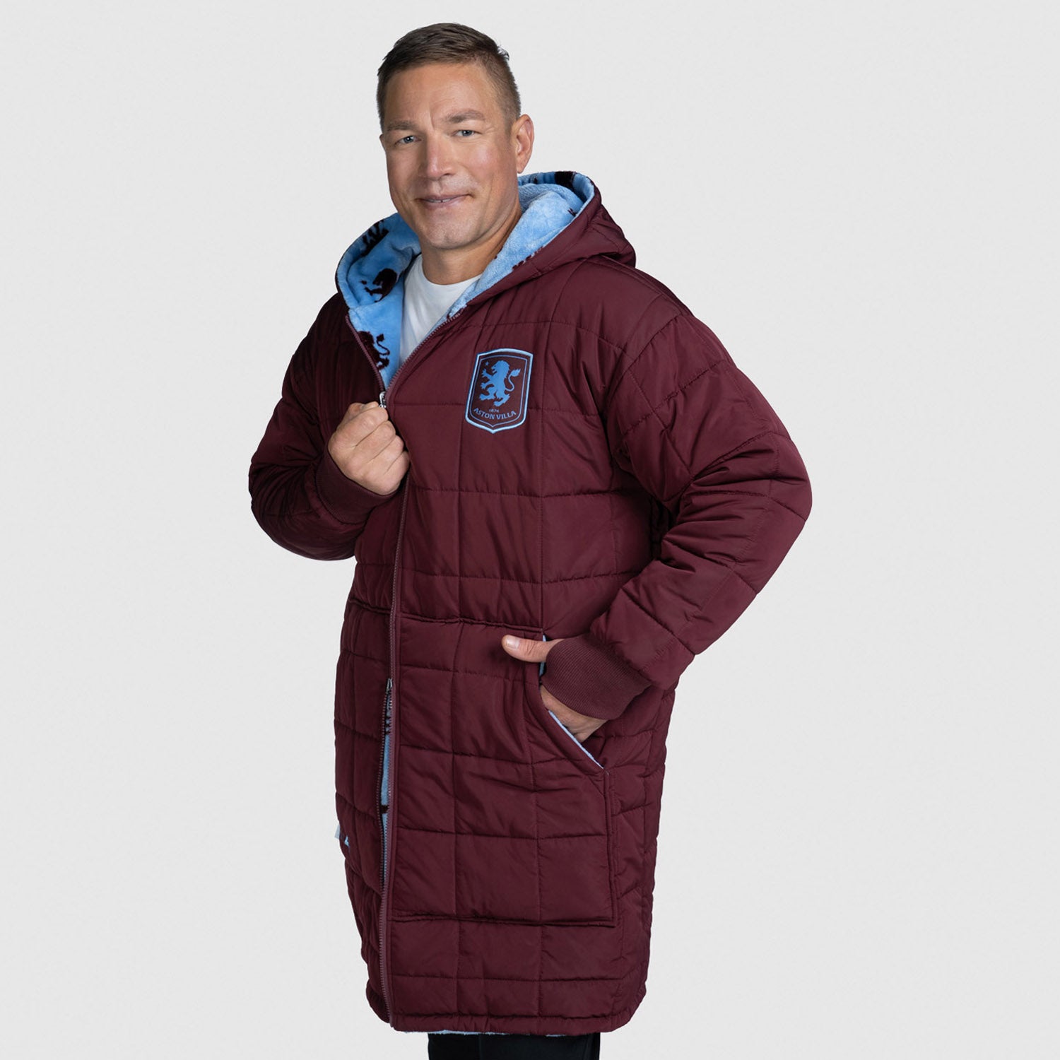 Man wearing a maroon quilted hooded coat with a blue logo patch, standing with one hand in pocket. size: Steven is 6” wearing a size OOD