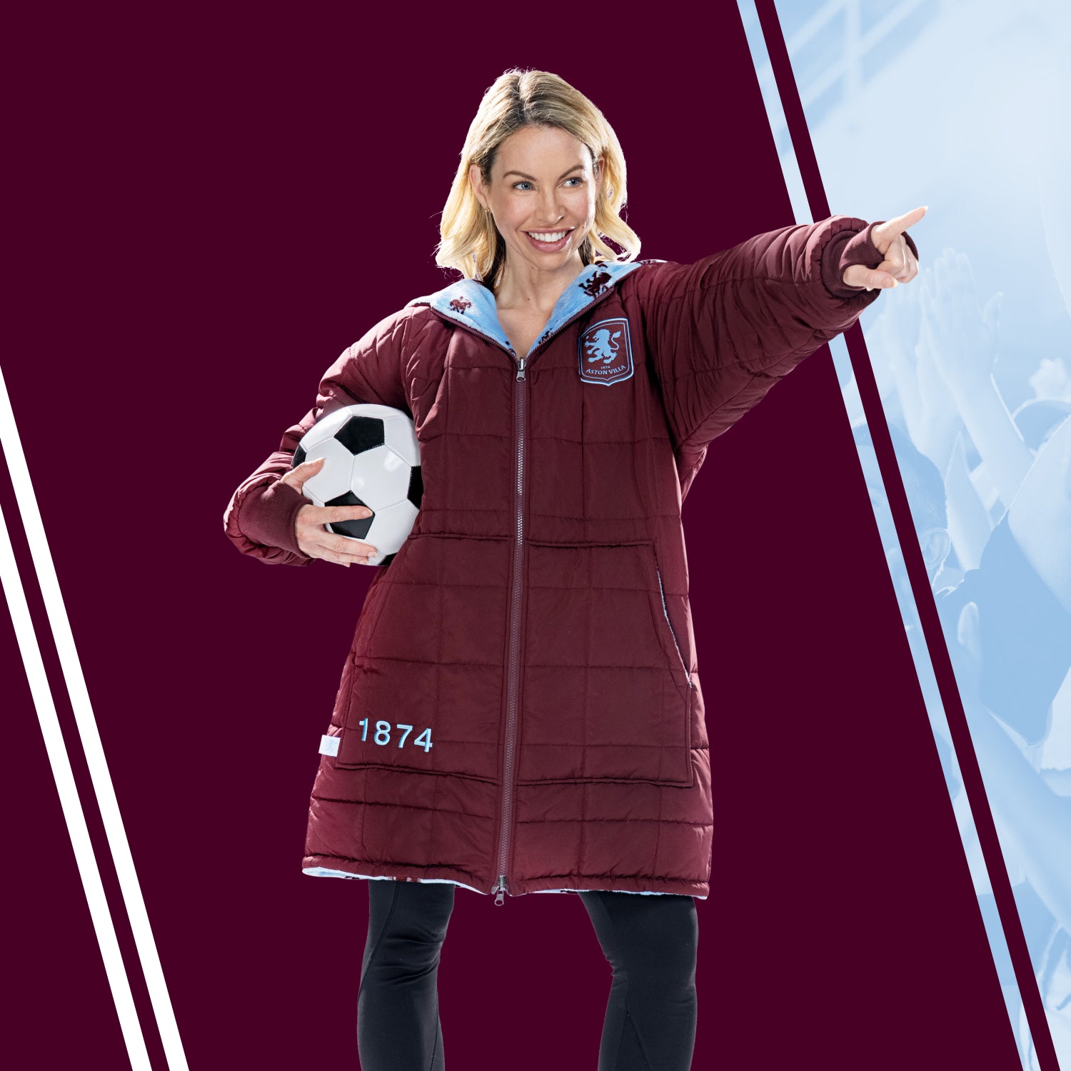 Woman holding a soccer ball wearing a maroon Aston Villa coat with logo and number 1874, pointing to the right