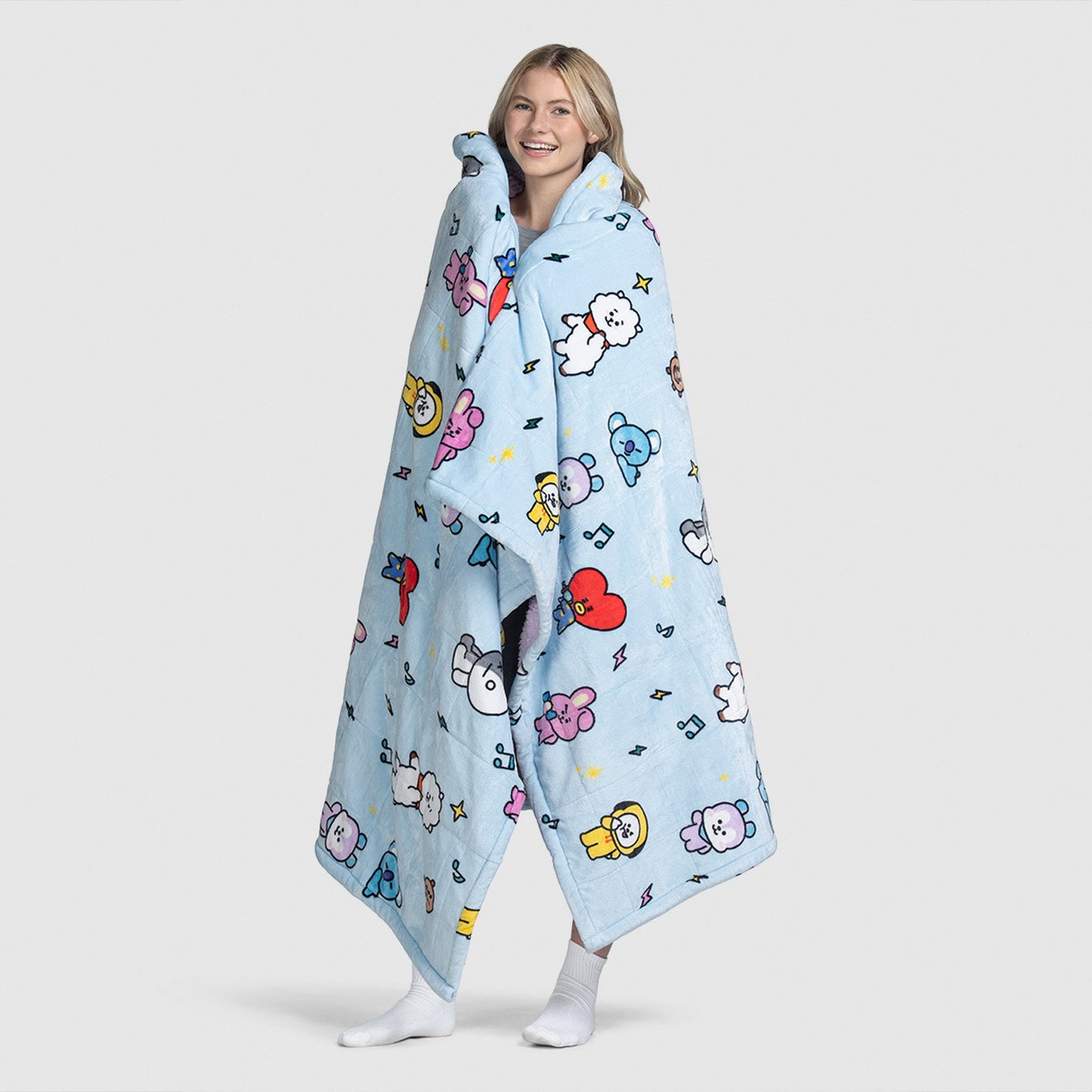 Person wrapped in a light blue blanket with colorful BT21 cartoon characters