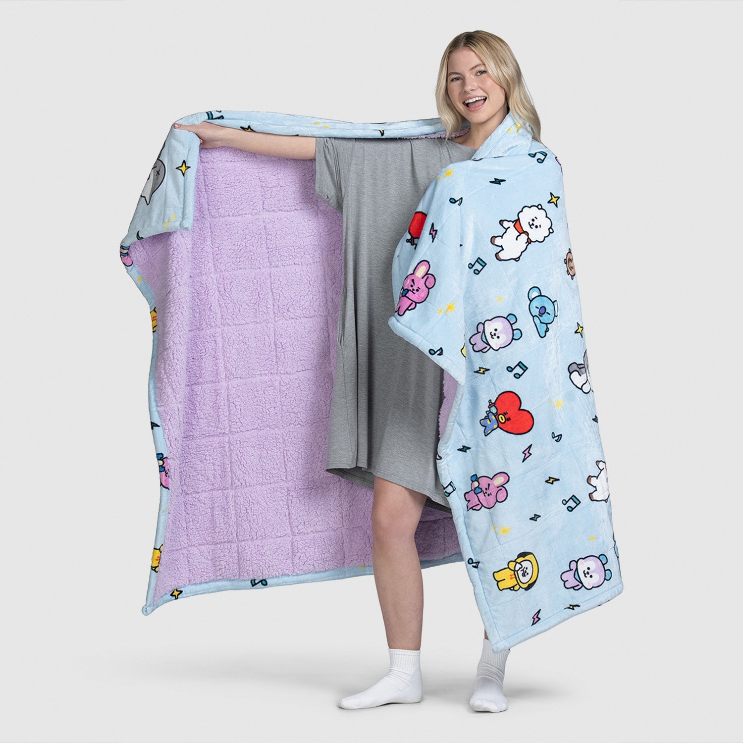 Woman holding and wearing a blue BT21 character-themed blanket with purple interior