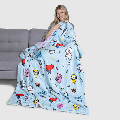 Woman holding a blue blanket with colorful BT21 cartoon characters printed on it