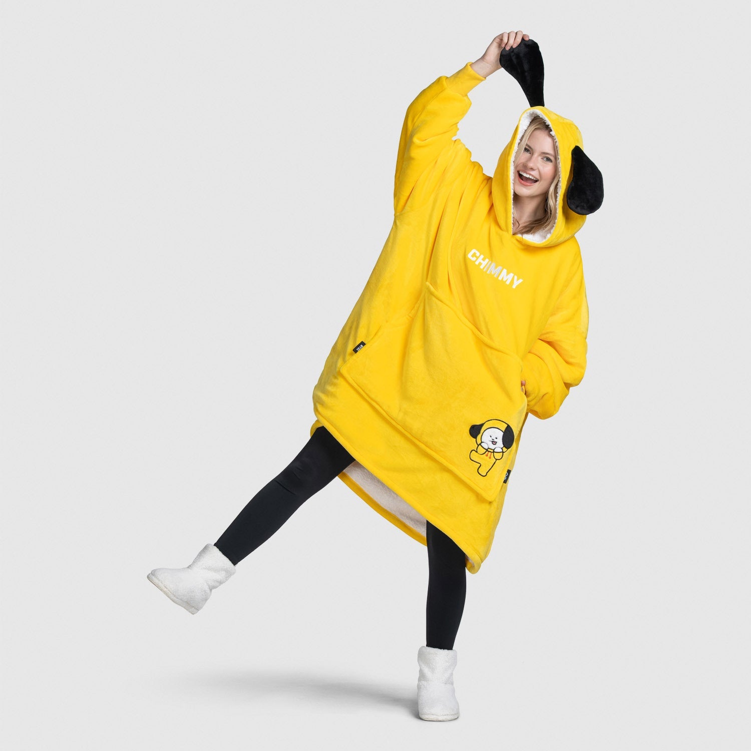 Person wearing oversized yellow hoodie with Chimmy character and black floppy ears, posing playfully.