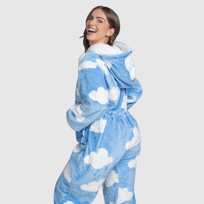 Woman smiling and looking over her shoulder wearing a blue hooded onesie with white cloud patterns