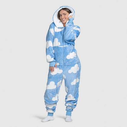 Woman wearing a blue onesie with white cloud patterns, smiling and posing with hood up