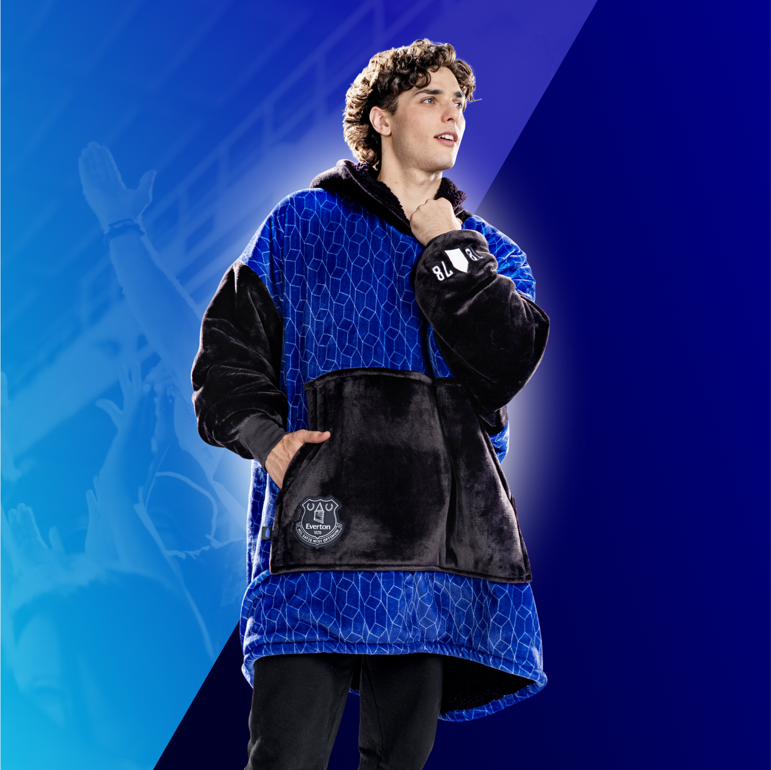 Young man wearing a blue and black Everton jacket with club logo on front pocket