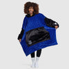 Woman wearing a blue and black Everton hoodie blanket with logo, smiling and holding the sides
