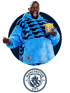 Man excitedly holding a popcorn bucket, wearing a blue and black patterned hoodie with a logo patch on the front pocket.
