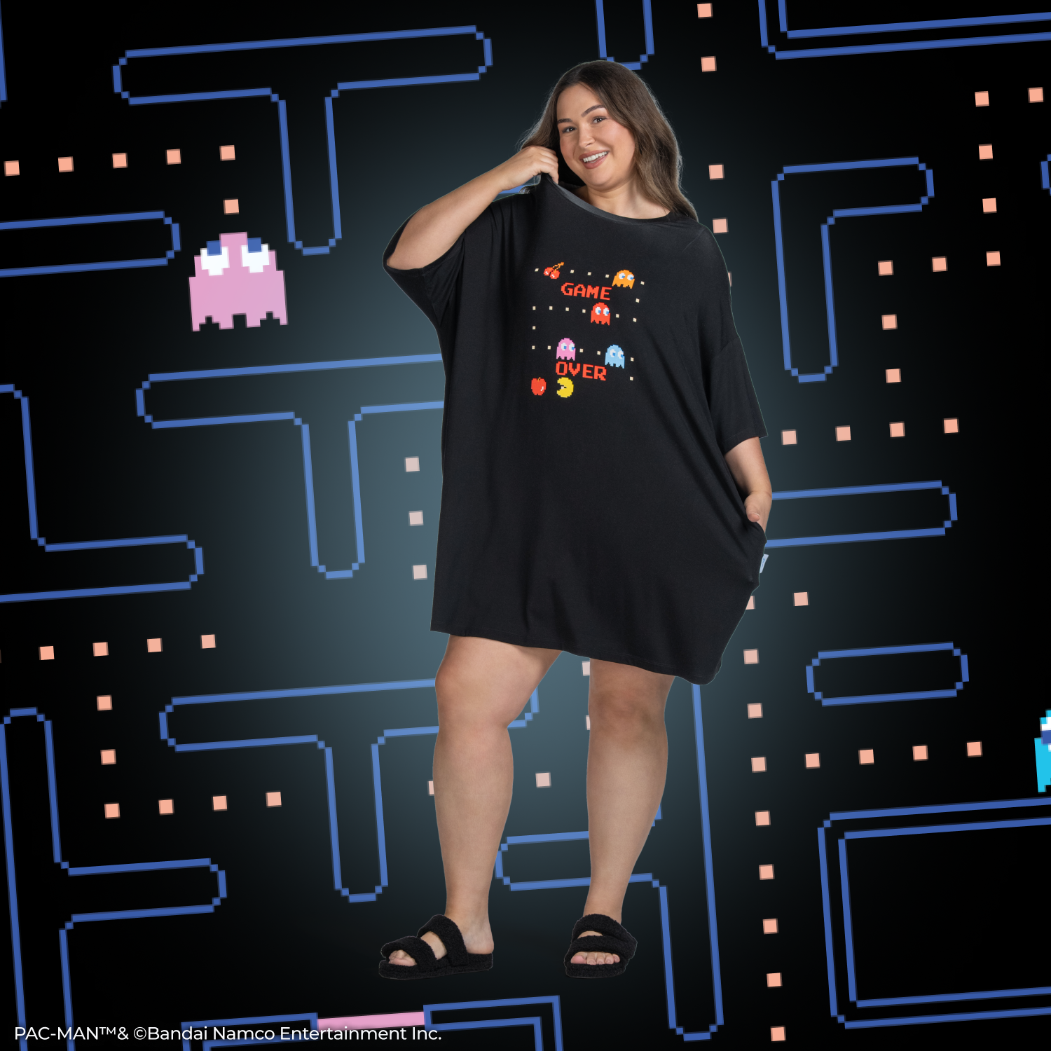 Person wearing a black dress with Pac-Man characters and the words 'GAME OVER' on the front.