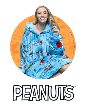 Woman wearing blue Peanuts-themed hoodie blanket with Snoopy and Woodstock, Peanuts logo below