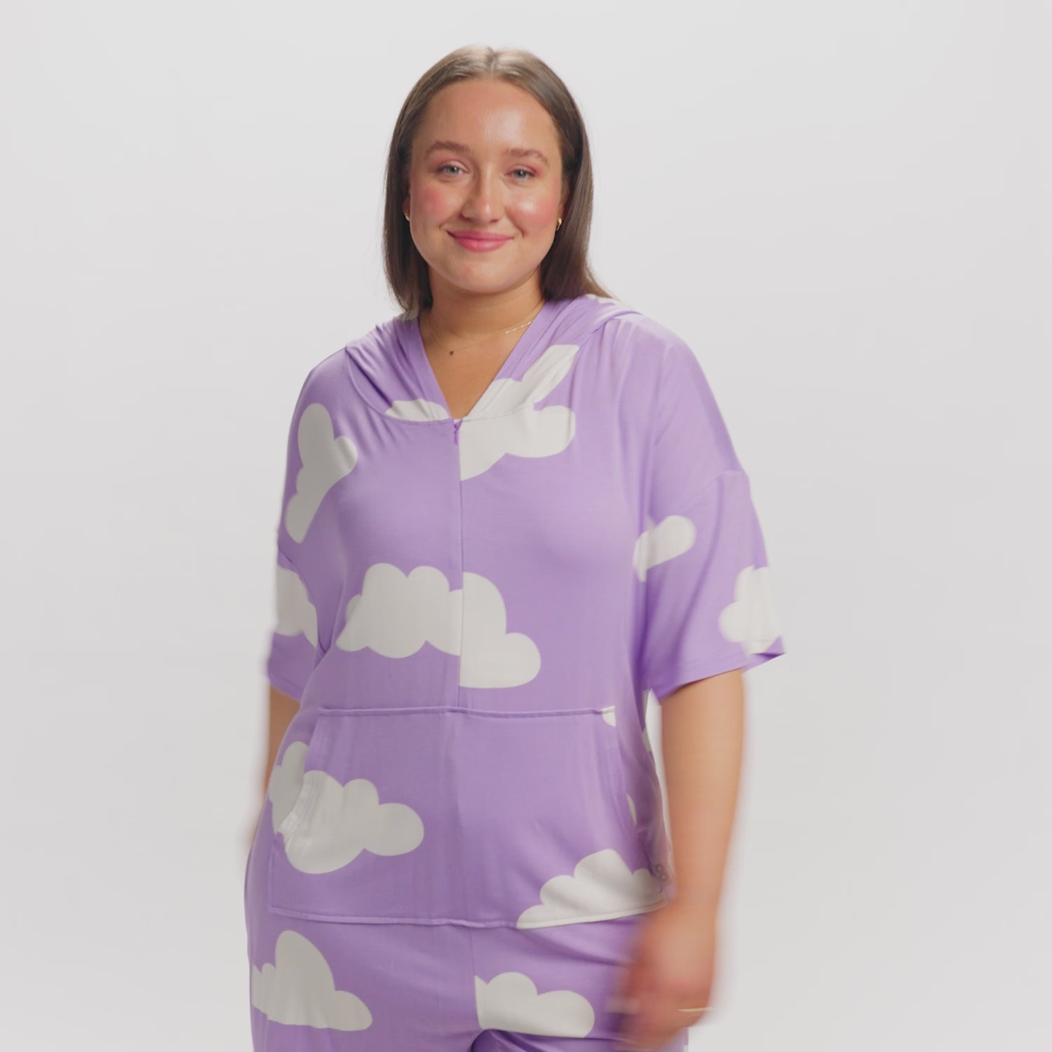Woman wearing a purple top with white cloud patterns, smiling at the camera