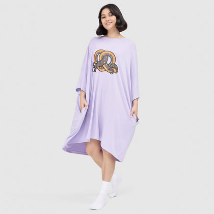 Woman wearing a lavender dress with a graphic of a snake wrapped around a pretzel on the front