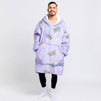 Man wearing a purple oversized hoodie and shorts with Bugs Bunny and Looney Tunes text patterns