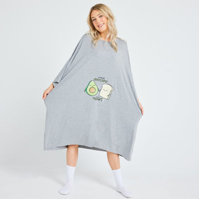 Woman wearing a gray oversized garment with a cartoon avocado and toast and text 