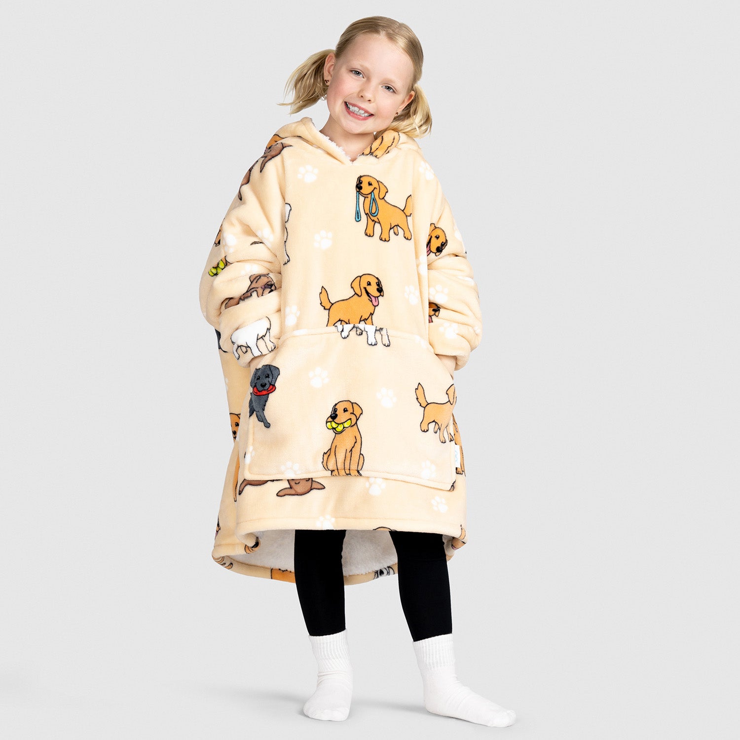 Child wearing an oversized beige hoodie with cartoon retriever dogs printed on it